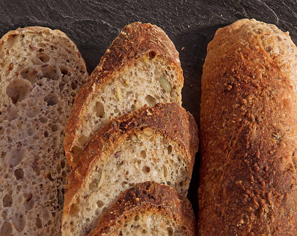 Slices of fresh homemade Alpine Baguette on black.