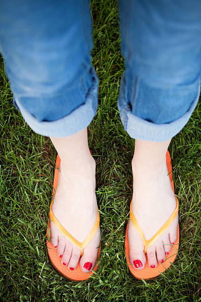 istock Feet In Orange Flip Flops 496196815