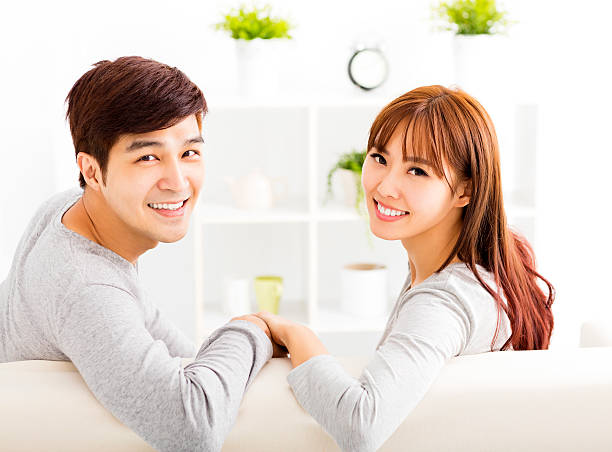 istock sweet young couple sitting in sofa 496198596