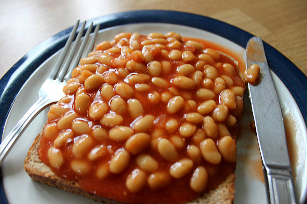istock Image of baked beans on toast, with knife and fork 496199011