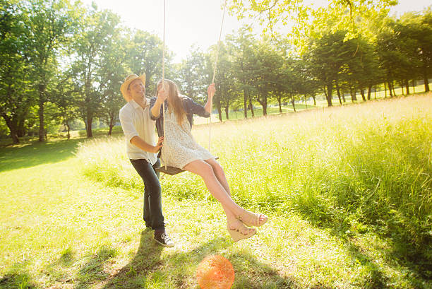istock Boyfriend pushing his girlfriend on a park swing 496200024