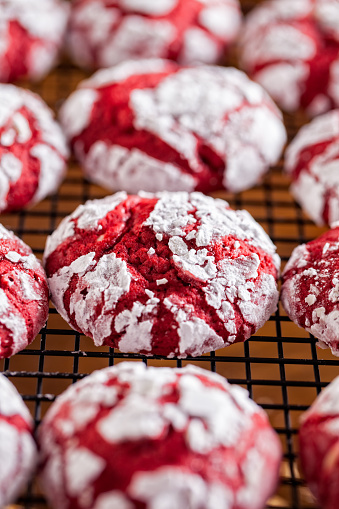 Red velvet crinkle cookies cooling on a baking rack for Christmas holiday baking