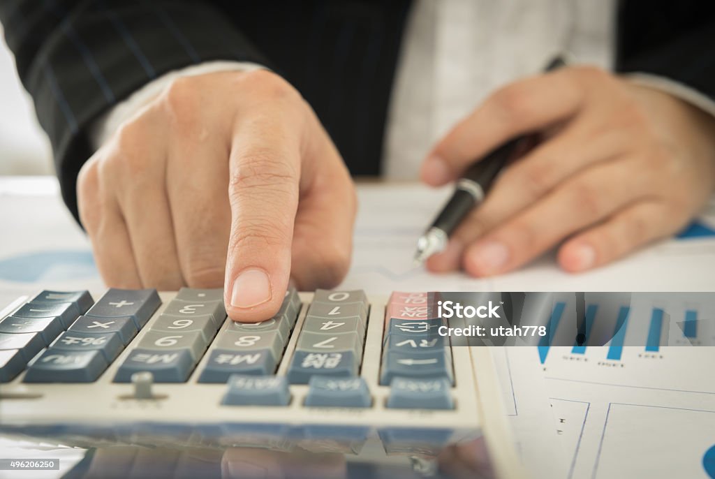 account and finance Businessman using a calculator to calculate the numbers 2015 Stock Photo