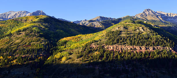 istock panoramic view of snow covered mountains and yellow aspen 496207408