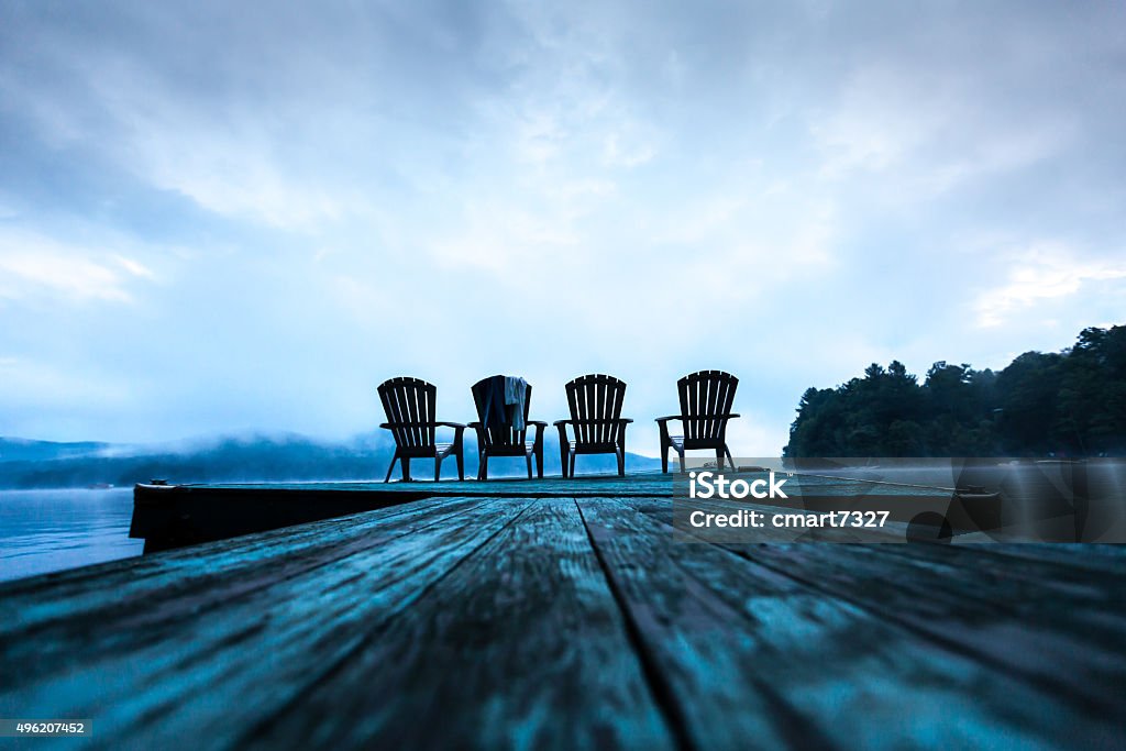 Adirondack chairs on dock Adirondack chairs on dock, overlooking Lake Sacandaga in Upstate New York. Towels draped over 1 chair from swimmers Adirondack Chair Stock Photo