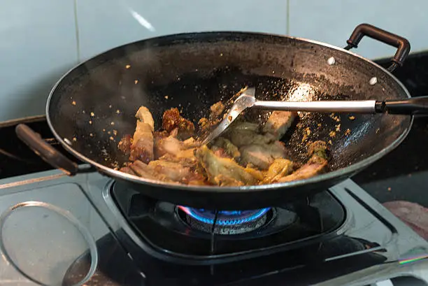 Chicken and pork in pan over the gas cooker