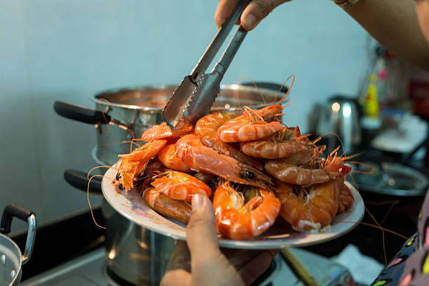 istock Picking steamed shrimp out ot the pot into the dish 496210616