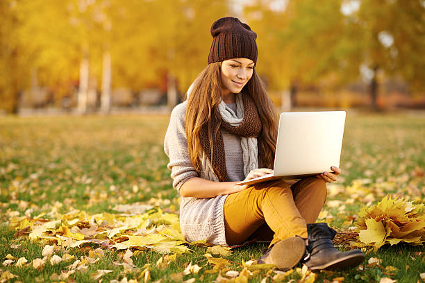 istock Using her laptop in the park on an autumn's day 496213302