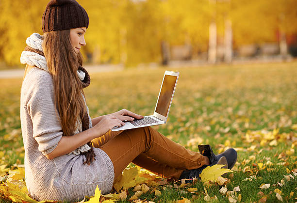 istock Using her laptop in the park on an autumn's day 496213564