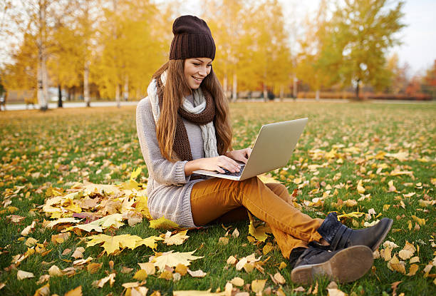 istock Using her laptop in the park on an autumn's day 496213670