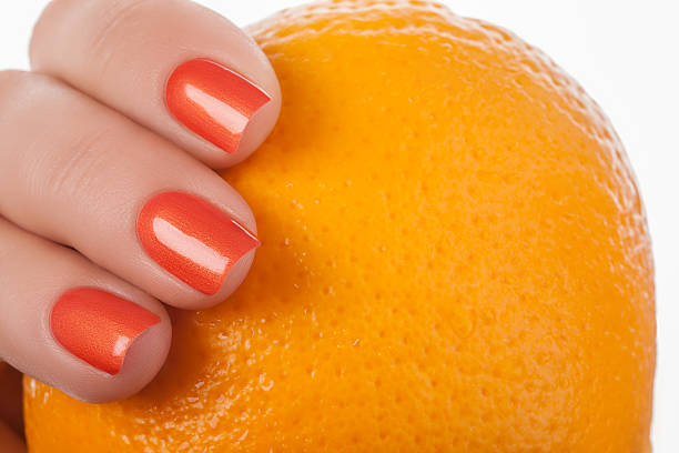 Orange nail polish. Orange nails on a white background with fruit. yellow nail polish stock pictures, royalty-free photos & images