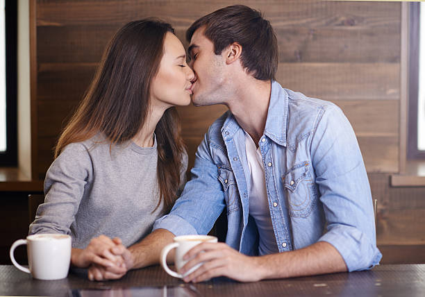 istock Affectionate young couple kissing in coffee shop 496229102