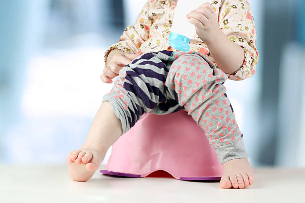 istock Children's legs hanging down from a chamber-pot on a blue 496231904