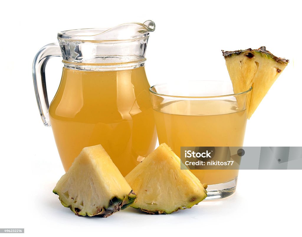 Full glass and jug of pineapple juice Full glass and jug of pineapple juice on a white 2015 Stock Photo