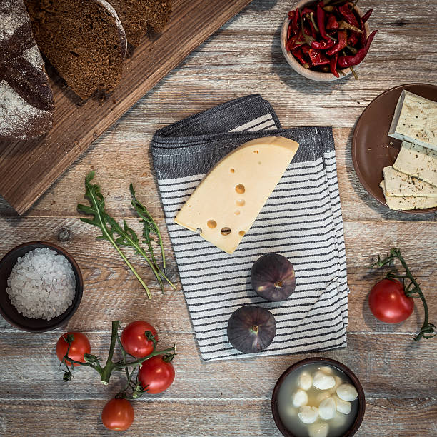 bread with cheeses and grapes on wooden background