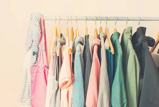 Photo of Pastel Color Female Clothes in a Row on Open Hanger