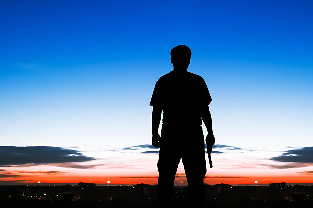 istock silhouette  man standing hand holding gun revolvers 496233882