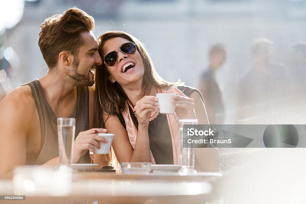Young loving couple enjoying their day in a cafe. Cheerful couple having fun while sitting together in a city cafe. Cafe Stock Photo