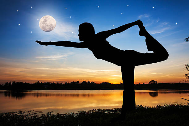 istock Silhouette young woman practicing yoga  on night full moon backg 496235248