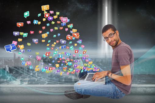Digital composite of casual man using laptop with app icons