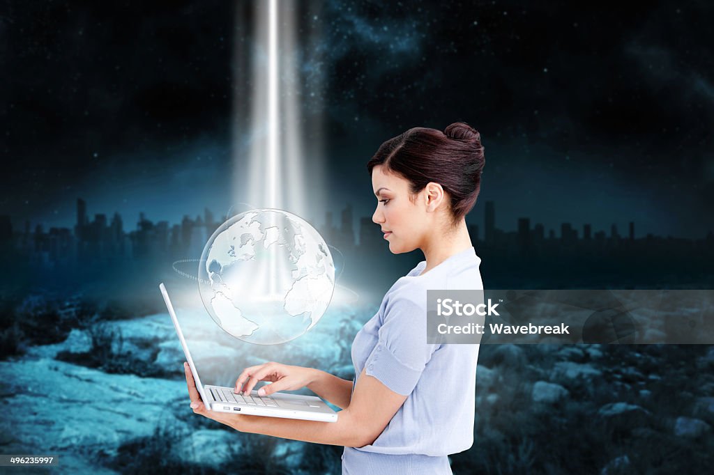 Hermosa mujer de negocios con computadora portátil con gráfico de tierra - Foto de stock de Rayo de luz libre de derechos