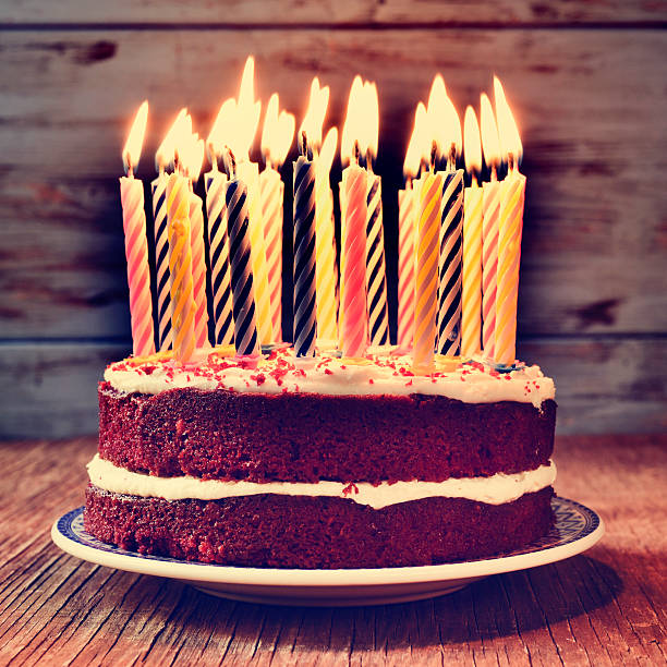 istock birthday cake with some lit candles, filtered 496236114