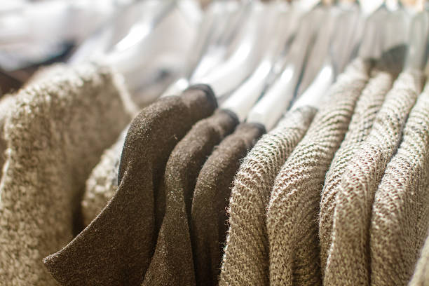 cinzento sweater pendurado em uma suspensão na loja - artex imagens e fotografias de stock