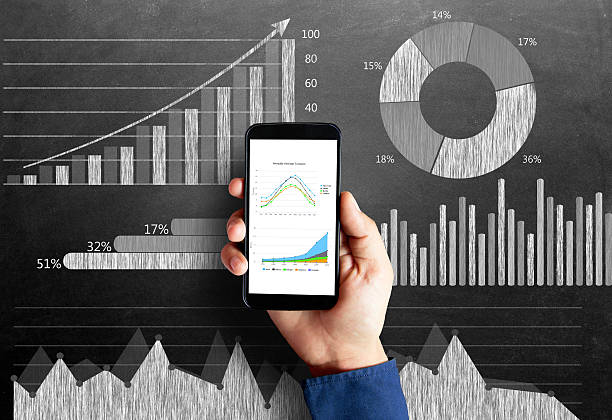 Business chart on blackboard with smart phone in human hand Businessman's hand holding smart phone with a diagram of business strategy drawn on blackboard that represents the concepts of business growth. progress report stock pictures, royalty-free photos & images