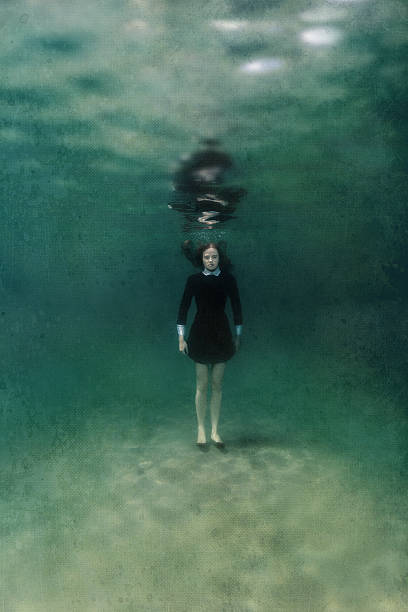 istock Girl in black dress underwater 496237404