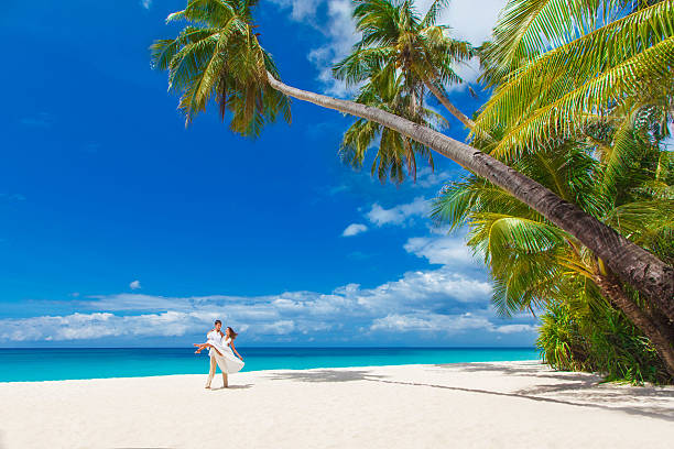 istock young loving couple on tropical beach with palm trees 496237485