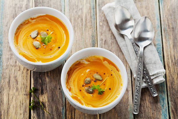 Fresh carrot or pumpkin soup in white bowl