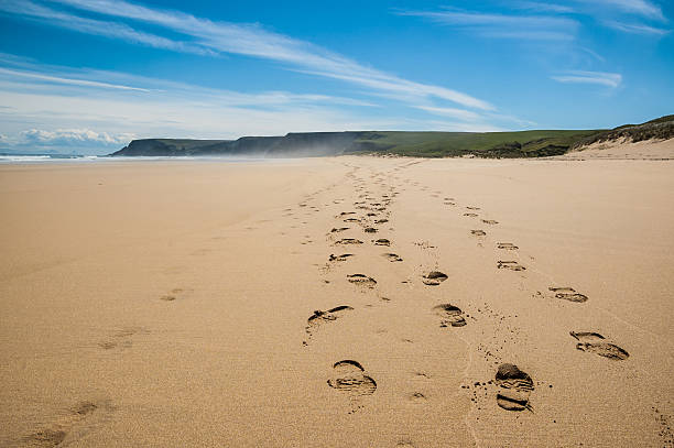 istock Footprints of hiking boots on a remote beach 496238625