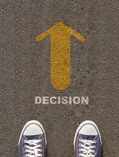 istock Pair of shoes standing on a road with arrow 496241349