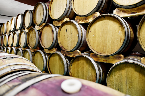 Detail shot with several wooden wine barrels in a cellar