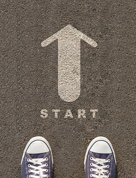 istock Pair of shoes standing on a road with arrow 496241633