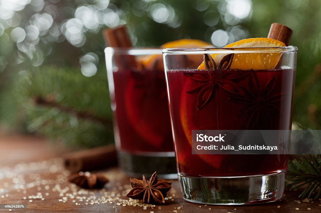 Mulled wine or gluhwein, traditional drink on winter holiday Christmas mulled wine or gluhwein with spices and orange slices on rustic table, traditional drink on winter holiday, magic light, selective focus Mulled Wine Stock Photo