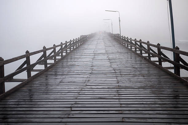 istock wood bridge into the fog 496243400