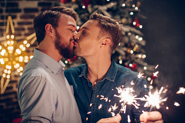 カップルはクリスマスのお祝いです。 - gay man homosexual men kissing ストックフォトと画像