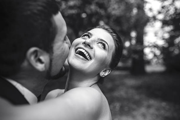 Beautiful wedding couple in each other's arms in the park, close angle