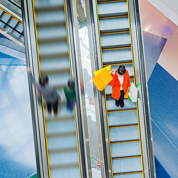 istock Female shopper standing on escalator 496256044