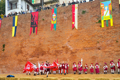 Calliano (AT), Italy - October 18, 2014: the village of Calliano, in the hilly region of Monferrato (Piedmont, Northern Italy), during an ancient historical reenactment, call Palio degli Asini (Donkeys Palio race). In the image: the performance of the historical flag wavers team. Photo taken in a public place.