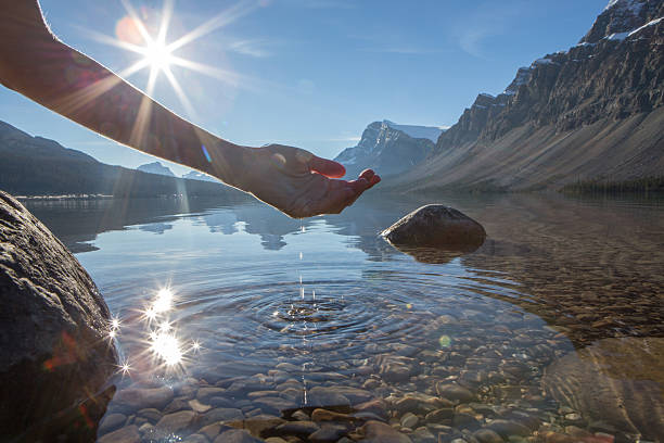 istock Human hand cupped to catch fresh water from mountain lake 496258964