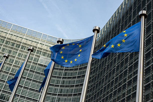 banderas de la unión europea frente al edificio (europa berlaymont - euro symbol european union currency currency banking fotografías e imágenes de stock