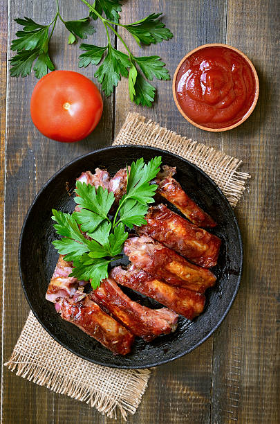 istock Grilled pork ribs on wooden table, top view 496261952