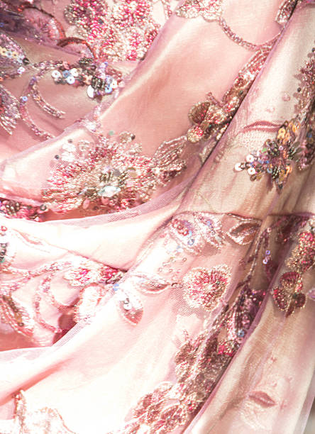 Pink lace with sequins, rhinestones and glitter Dallas, Texas, USA, November 8, 2015- Close up of a skirt of a dress. The material is decorated with sequins, rhinestones, and glitter. pink gown stock pictures, royalty-free photos & images