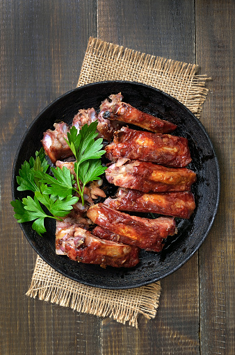 Roasted pork ribs in frying pan, top view