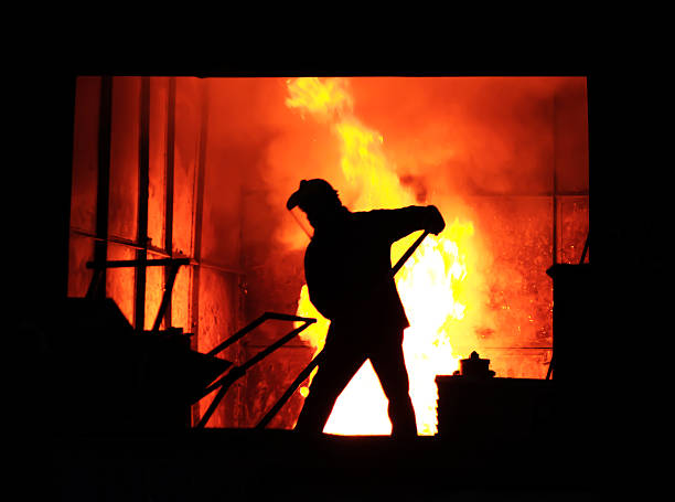 Man is working in the splashing molten iron stock photo