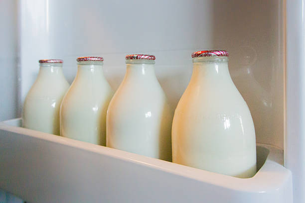 botellas de leche en refrigerador de puerta - milkman fotografías e imágenes de stock