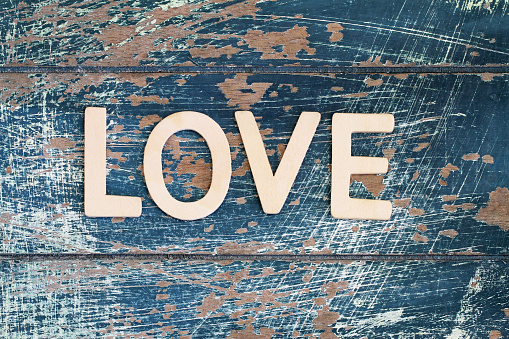 Word love written on rustic wooden surface