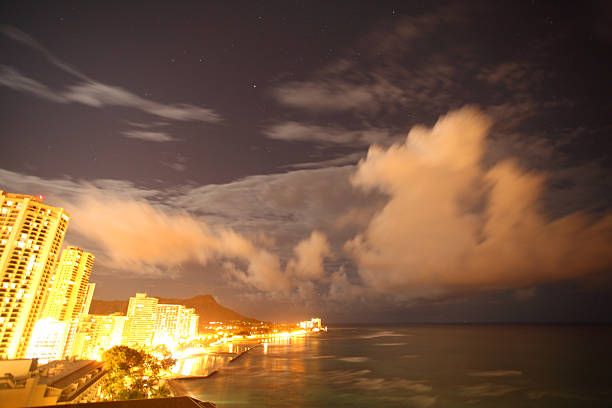 vista nocturna de la playa de waikiki - hawaii islands big island waikiki beach fotografías e imágenes de stock